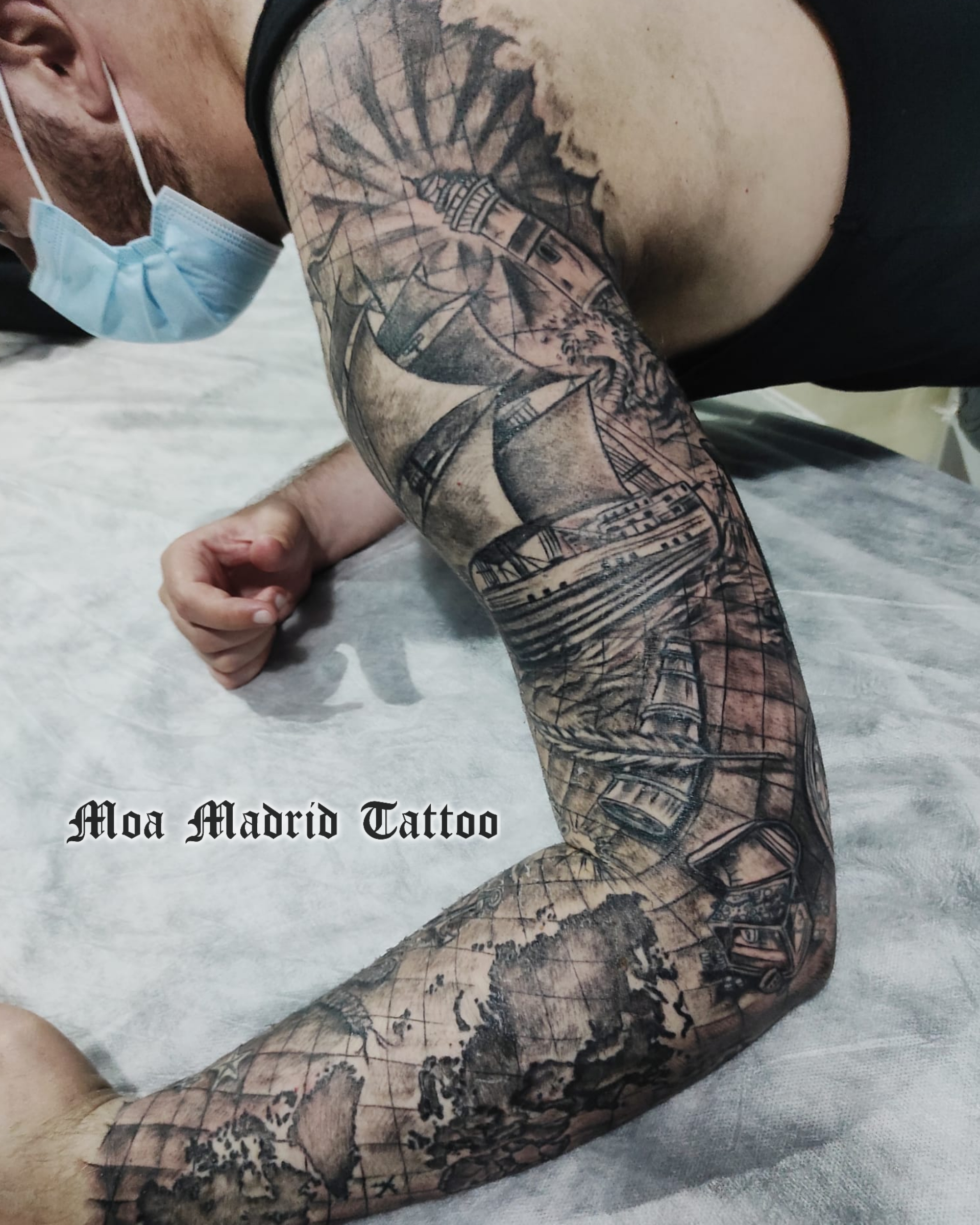 Brazo entero lleno de tatuajes en realismo sobre los viajes y el mar