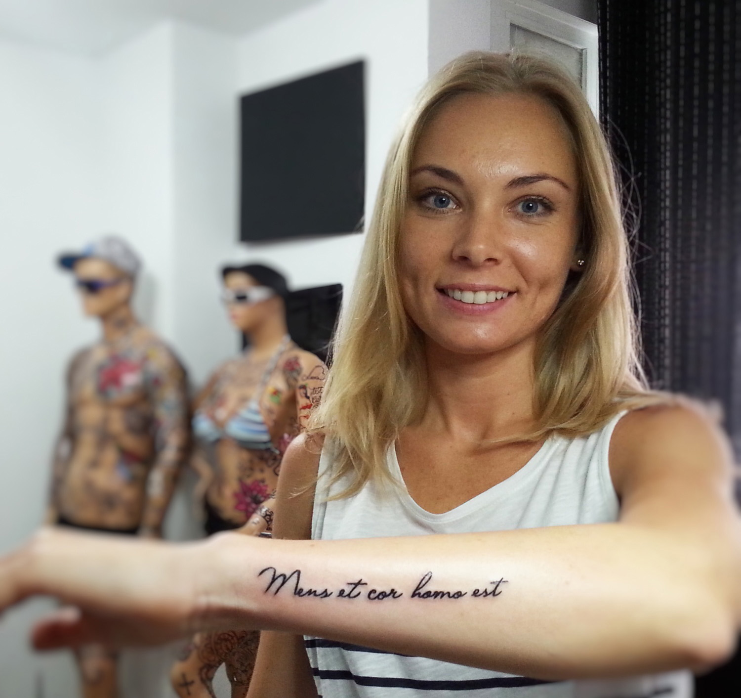 Tatuaje de frase en latín en el antebrazo 