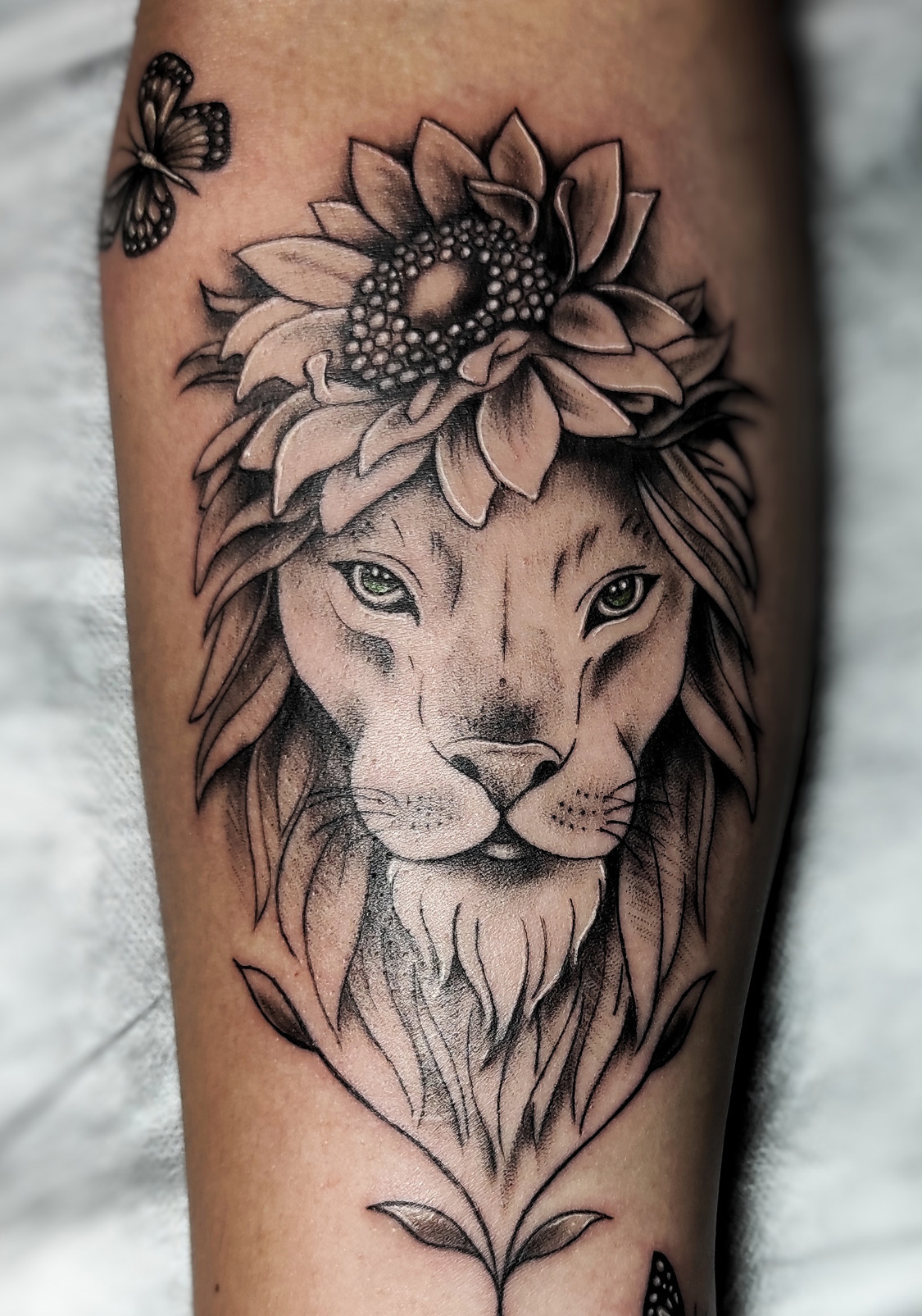 Tatuaje de león, flor y mariposas en Madrid